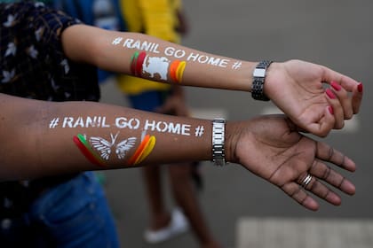 Dos mujeres muestran sus brazos con el mensaje "Ranil vete a casa", en alusión al exprimer ministro y actual presidente de Sri Lanka, Ranil Wickremesinghe, durante una protesta en Colombo, Sri Lanka, el 17 de julio de 2022. 
