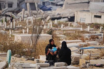 Dos mujeres palestinas visitan las tumbas de sus familiares en el cementerio Jeque Radwan, en la Ciudad de Gaza