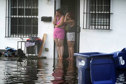 Dos mujeres reaccionan al ver inundaciones en su calle, el jueves 13 de junio de 2024, en North Miami , Florida