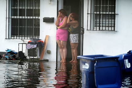 Dos mujeres reaccionan al ver su calle inundada, el jueves 13 de junio de 2024, en North Miami, Florida. (AP Foto/Marta Lavandier)
