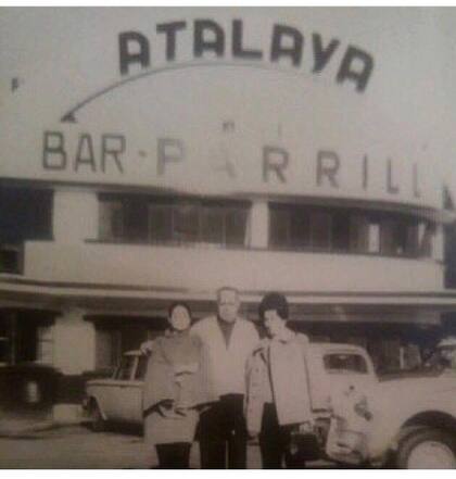 Dos mujeres sonríen para la cámara junto a un trabajador del restaurant