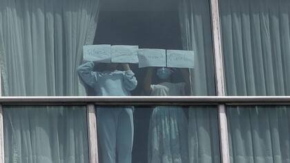 Dos niñas deportadas con el mensaje "Por favor, salva a las niñas afganas" desde una habitación del hotel