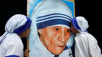 Dos niñas vestidas como Misioneras de la Caridad besan un retrato de la Madre Teresa de Calcuta durante una ceremonia en su honor en Bhopal (India), el de agosto de 2010