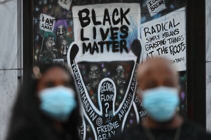 Dos personas con barbijo participan de una protestas en Black Lives Matter Plaza en Washington, DC el 14 de noviembre de 2020