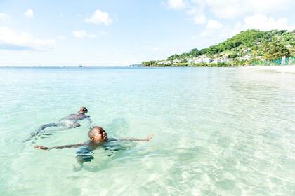 Dos personas disfrutan del agua cristalina de las costas de Grenada