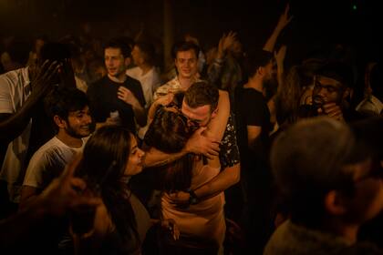 Dos personas se abrazan en medio de la pista de baile en la discoteca Egg London en las primeras horas del 19 de julio de 2021 en Londres, Inglaterra