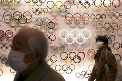 Dos personas usan máscaras mientras visitan el recién inaugurado Museo Olímpico de Japón ubicado cerca del Nuevo Estadio Nacional, el domingo 23 de febrero de 2020 en Tokio.