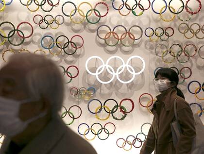 Dos personas utilizan barbijos cerca del Museo Nacional Olímpico en Tokio.