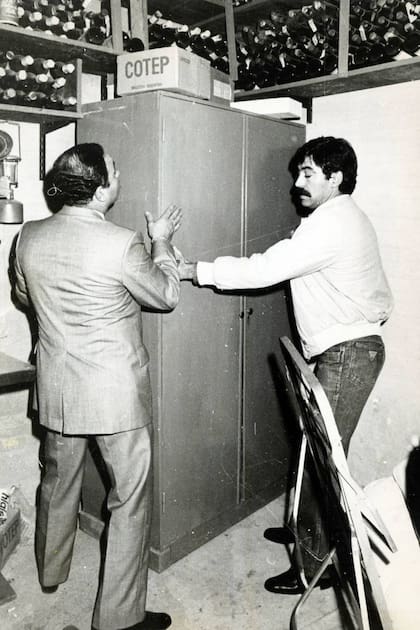 Dos policías mueven el armario que cubría el acceso al calabozo en el que estaba detenida Nélida Bollini de Prado, víctima del secuestro de los Puccio