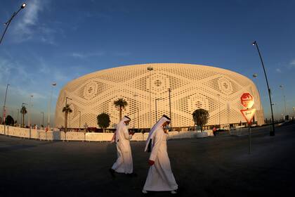Dos qataríes pasean por las inmediaciones del Estadio Thumama al atardecer