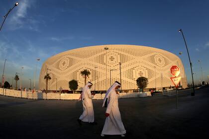 Dos qataríes pasean por las inmediaciones del Estadio Thumama al atardecer
