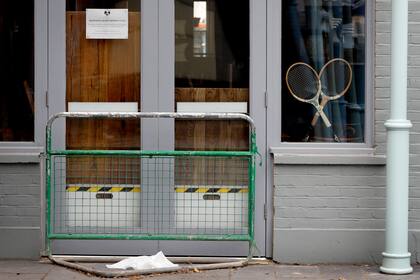 Raquetas de tenis en la vidriera de un pub cerrado de Wimbledon; la cancelación del torneo es un golpe para los comercios.