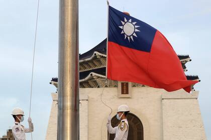 Dos soldados arrían la bandera nacional durante una ceremonia diaria en la Plaza Libertad del Monumento Chiang Kai-shek en Taipéi, Taiwán. (AP Foto/Chiang Ying-ying)