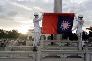 Dos soldados doblan la bandera nacional durante la ceremonia diaria de izado de bandera en la plaza Liberty en Taipéi, Taiwán