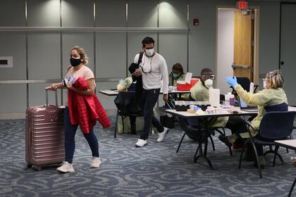 Dos visitantes procedentes de Colombia reciben sus vacunas Pfizer-BioNtech en el Aeropuerto Internacional de Miami