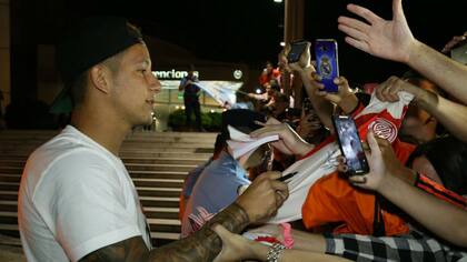 Driussi le firma autógrafos a los hinchas al llegar a Córdoba