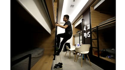 Du Xianchang, un ingeniero de la empresa Baishan Nube, sube a la cama en un cuarto individual para dormir en la oficina después de terminar el trabajo a media noche