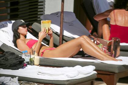 Dua Lipa usa un bikini fucsia fuerte mientras se relaja junto a la piscina en compañía un hombre misterioso en Miami