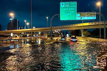 Conductores circulan por una calle inundada después de fuertes lluvias en Dubai temprano el 17 de abril de 2024.