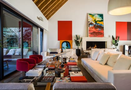 Dúo de sillones de los años 60 retapizados en pana. Al fondo, acrílico rojo de Juan José Cambre y un retrato firmado por Luna Álvarez Castillo, hija del anfitrión