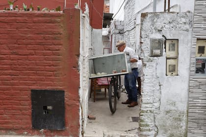 Durante la temporada de clases, Oscar sale a vender manzanas caramelizadas en bicicleta en su barrio de Lanús.