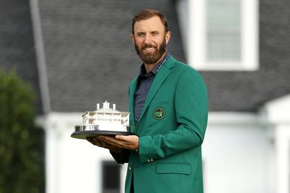 Dustin Johnson posa con el saco verde y el Trofeo de Maestros luego de ganar el Masters de Augusta.