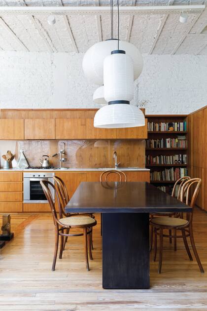 Eclecticismo que funciona: sillas Thonet restauradas, mesa laquedada hecha sobre un diseño de Alberto Churba y lámparas ‘Formakami’, de la firma danesa &Tradition.