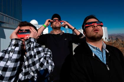 La gente con sus anteojos para ver el eclipse solar