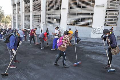 Indígenas, estudiantes voluntarios y residentes locales limpian las calles.