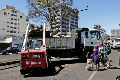 Una pala mecánica carga basura en un camión.