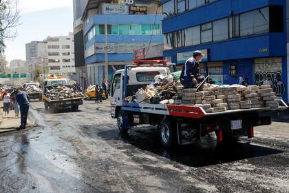 Varios camiones cargados de ladrillos y basura por las calles de la ciudad.