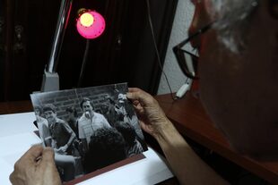 Édgar Jiménez, el Chino, sostiene fotos que le tomó al capo en las calles de Medellín