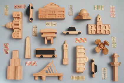 Edificios y autos para armar recorridos por la ciudad. Las piezas de Lola y Chango son pequeñas esculturas de colección en maderas de kiri, paraíso y guatambú.