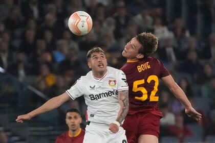 Edoardo Bove, que anotó el gol de Roma, lucha por la pelota con Exequiel Palacios, de Bayer Leverkusen, en el duelo en el estadio Olímpico.