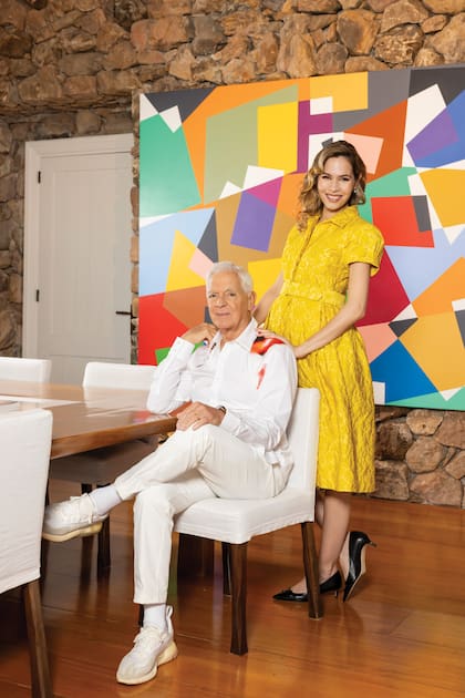Eduardo, con camisa de Alexander McQueen, y Elina, con vestido en brocato de Carolina Herrera, posan en el comedor. El gran cuadro que vemos es una obra de Gachi Hasper, de 2011.