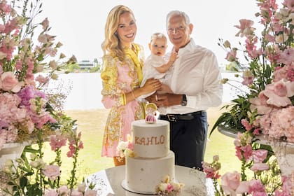 Eduardo, Elina y Kahlo posan en
su casa con la torta de bautismo y
espectaculares ramos de flores en
distintos tonos de rosa