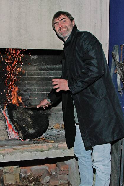 Eduardo encendió el fuego de la parrilla para calefaccionar los ambientes exteriores.