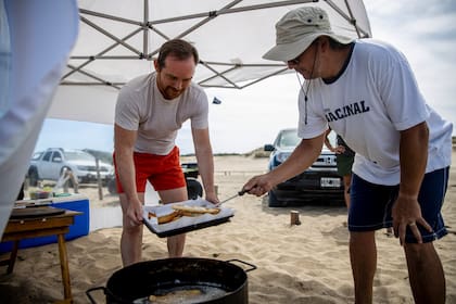 Eduardo Pearson y Marcelo Martínez Casad fríen milanesas en "La Frontera", una playa ideal para un verano con distanciamiento social.