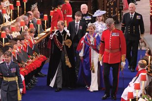 Eduardo y Sofía, duques de Edimburgo, caminan por la nave central de Westminster junto a sus hijos, Lady Louise Mountbatten-Windsor y James, conde de Wessex. Eduardo, con el manto de la Orden de la Jarretera y Sofía, con el de la Real Orden Victoriana.
