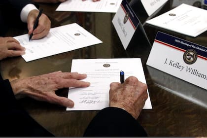 En esta foto de 2016, miembros del Colegio Electoral de Mississippi firman certificados de voto 