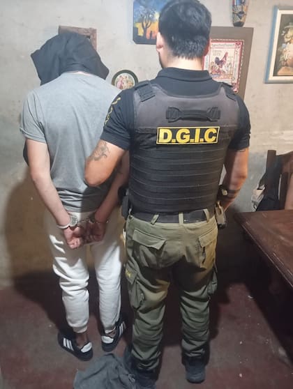 Efectivos de la Dirección General de Investigaciones Criminales custodian a otro de los detenidos durante un operativo vinculado a la causa