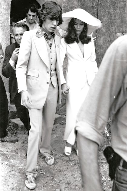 El 12 de mayo de 1971, en Saint-Tropez, el rockstar Mick Jagger y Bianca Pérez-Mora Macías tuvieron una boda que hizo historia, en la que la socialité nicaragüense rompió moldes con el look: llevó un saco de smoking de Yves Saint Laurent, sin nada debajo, falda larga y capelina con velo. Controvertido y audaz para la época, se convirtió en un símbolo de elegancia y libertad que, décadas después, sigue inspirando a novias como Dua Lipa