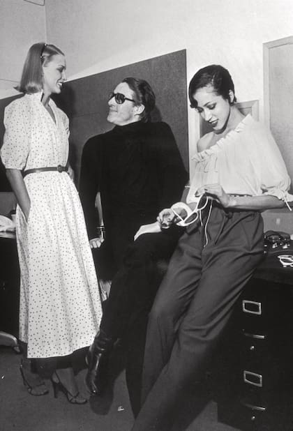 El 19 de enero de 1978, Halston conversa con dos de sus modelos antes de la presentación de su colección verano en Nueva York.