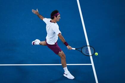 El 26 de enero de 2020, Roger Federer en devolución contra el húngaro Marton Fucsovics durante su partido individual masculino en el día siete del torneo de tenis del Abierto de Australia en Melbourne