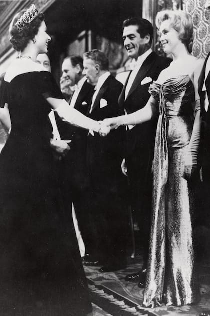 El 29 de octubre de 1956, en Londres, Isabel II le da la mano a Marilyn Monroe –a su lado Victor Mature– tras el estreno real de la película La batalla del Río de la Plata.