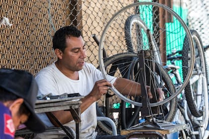 José Luis Araujo es bicicletero desde hace 15 años; tiene un puesto sobre la vereda que arma y desarma todos los días; sostiene que ve mayor movimiento, aunque aún no impactó en su actividad