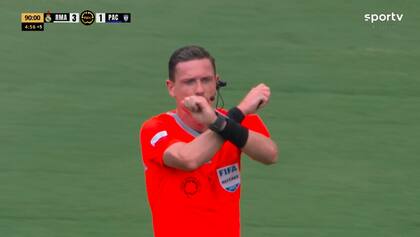 El aárbitro brasileño, Ramon Abatti Abel, cruzando sus brazos, lo que significa que activó el protocolo por una supuesta situación de racismo