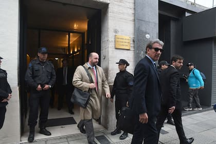 El abogado Rafael Cúneo Libarona (adelante, de anteojos oscuros), defensor de Francisco Sáenz Valiente, al salir de la audiencia en la Cámara del Crimen