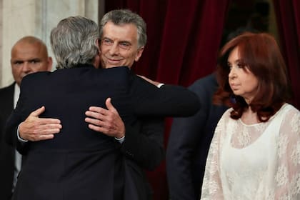 El abrazo de Mauricio Macri a Alberto Fernández. A un lado, Cristina Kirchner con gesto adusto