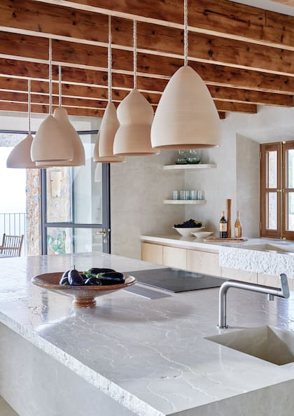 El acabado rústico del borde de la mesada y la pileta de olavar se volverá a ver en las bachas de los baños.